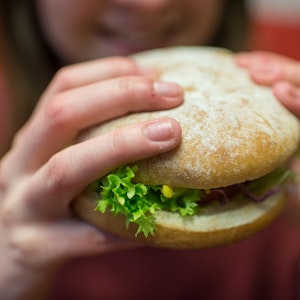 Das Foto, auf dem eine Frau einen Burger in den Händen hält, wurde im Februar 2016 in München aufgenommen und dient hier als Symbolfoto.