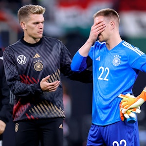 Matthias Ginter (l.) streckt seinem Nationalmannschaftskollegen Marc-André ter Stegen (r.) nach dem Länderspiel am 23. September 2022 gegen Ungarn die Hand entgegen.
