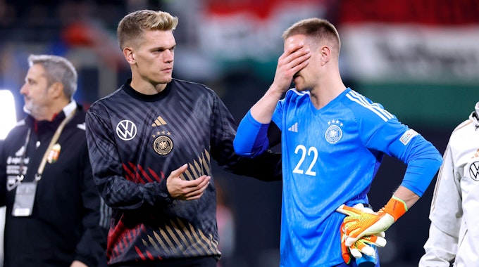 Matthias Ginter (l.) streckt seinem Nationalmannschaftskollegen Marc-André ter Stegen (r.) nach dem Länderspiel am 23. September 2022 gegen Ungarn die Hand entgegen.