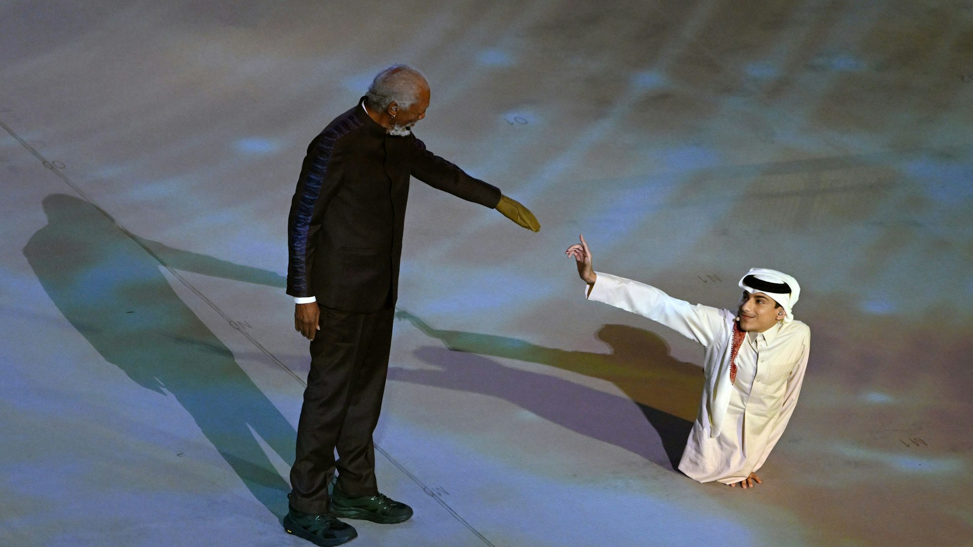 Morgan Freeman (l.) und Paralympics-Sportler Ghanim Al-Muftah reichen sich die Hand bei der WM-Eröffnungsfeier in Katar.