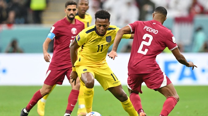 Michael Estrada setzt sich im WM-Eröffnungsspiel gegen zwei katarische Gegenspieler durch.