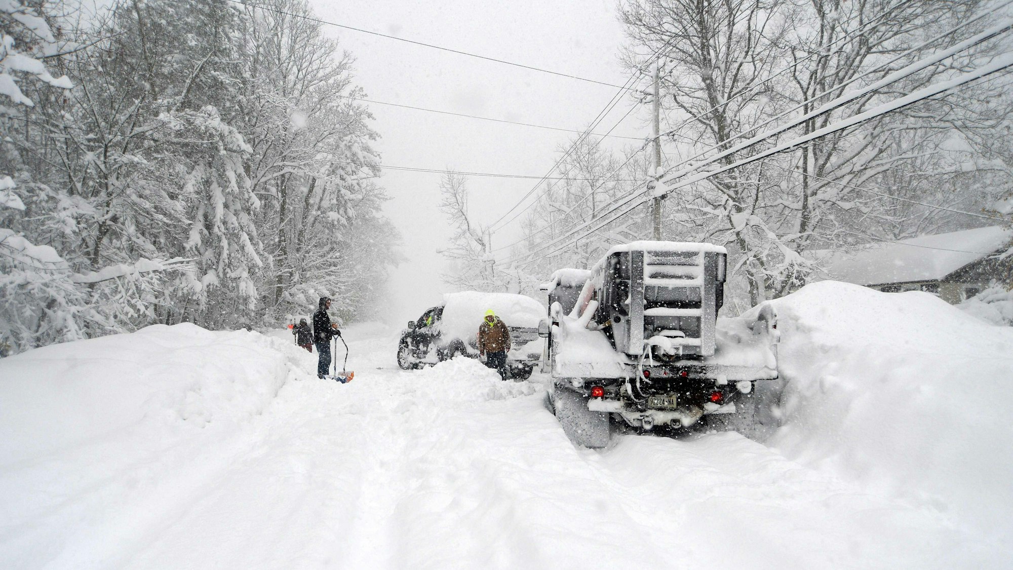 Freiwillige helfen Menschen, die mit ihren Autos im Schnee steckengeblieben sind.