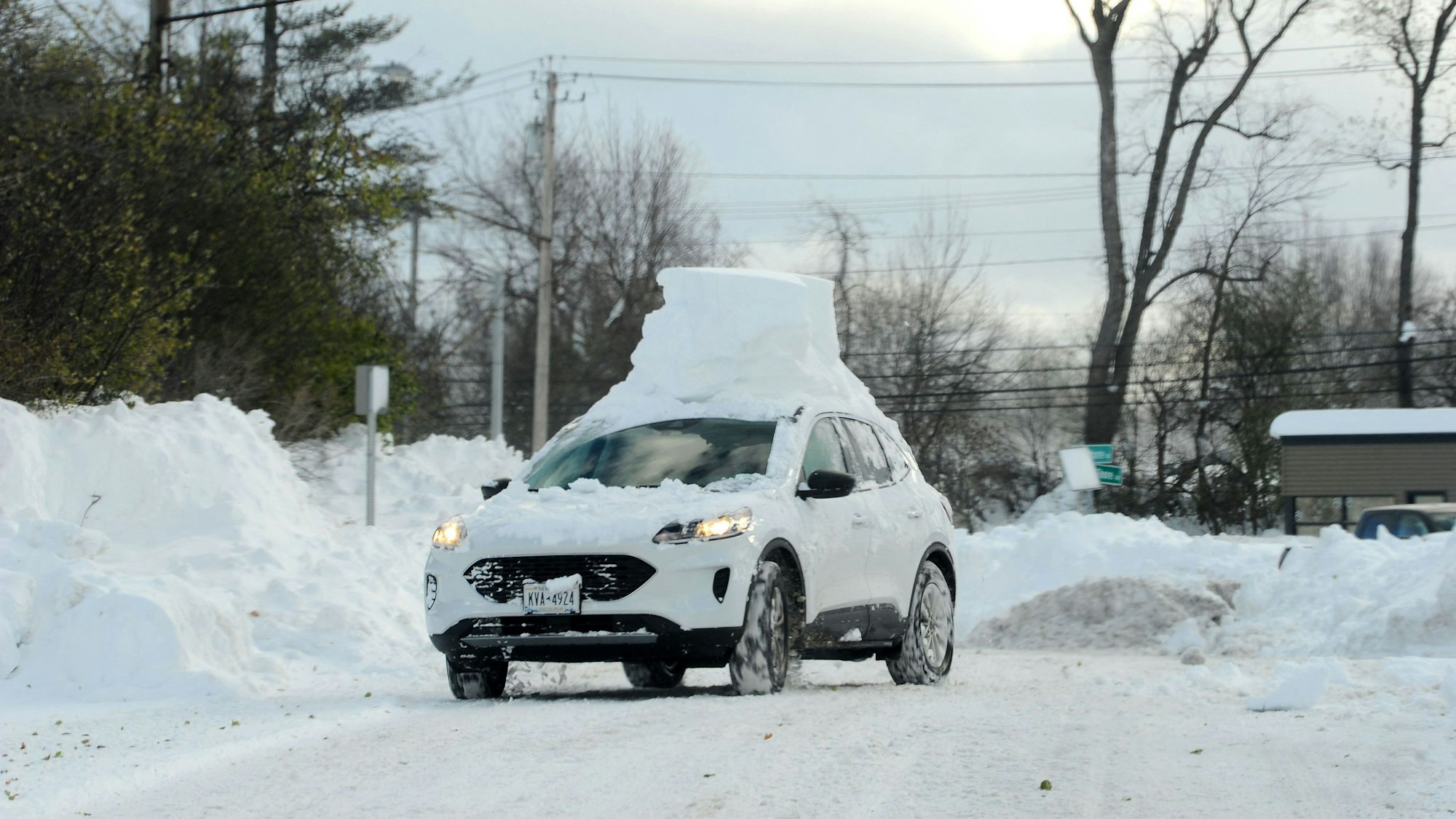 Auf einem weißen Auto liegt ein Haufen Schnee in Hamburg, New York.