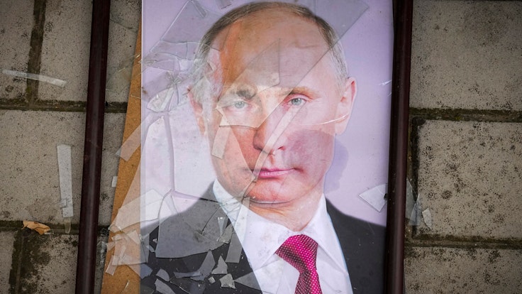 Ein Foto Wladimir Putins liegt in einem zerbrochenen Bilderrahmen.