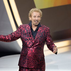 Moderator Thomas Gottschalk kommt bei „Wetten, dass..?“ in Friedrichshafen auf die Bühne. Er trägt einen rot-glänzenden Anzug mit Leoparden-Muster.