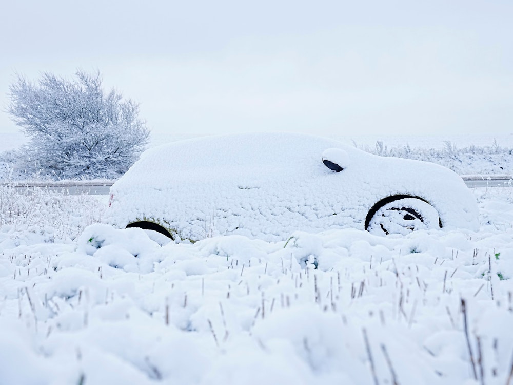 Ein Auto ist in Ostjütland mit Schnee bedeckt.