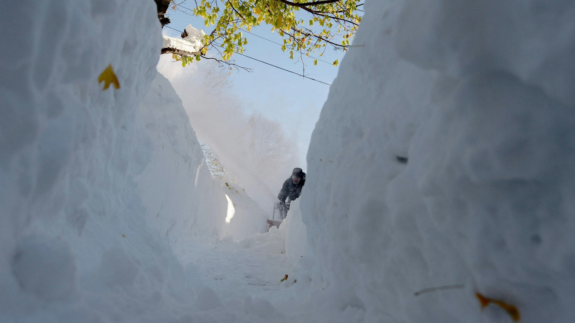 Ein Mann räumt am Sonntag seinen Gehweg nach dem heftigen Schneesturm in Buffalo, New York. Es ist hauptsächlich Schnee zu sehen.