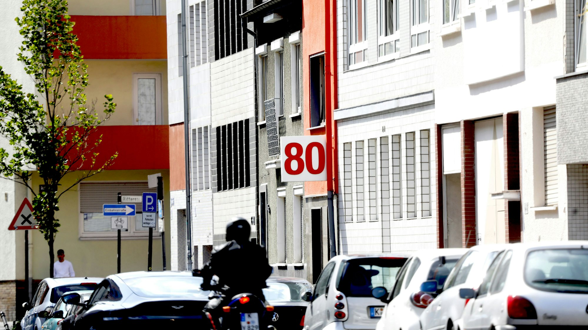 Ein Motorradfahrer fährt auf der Eintrachtstraße an geparkten Autos vorbei