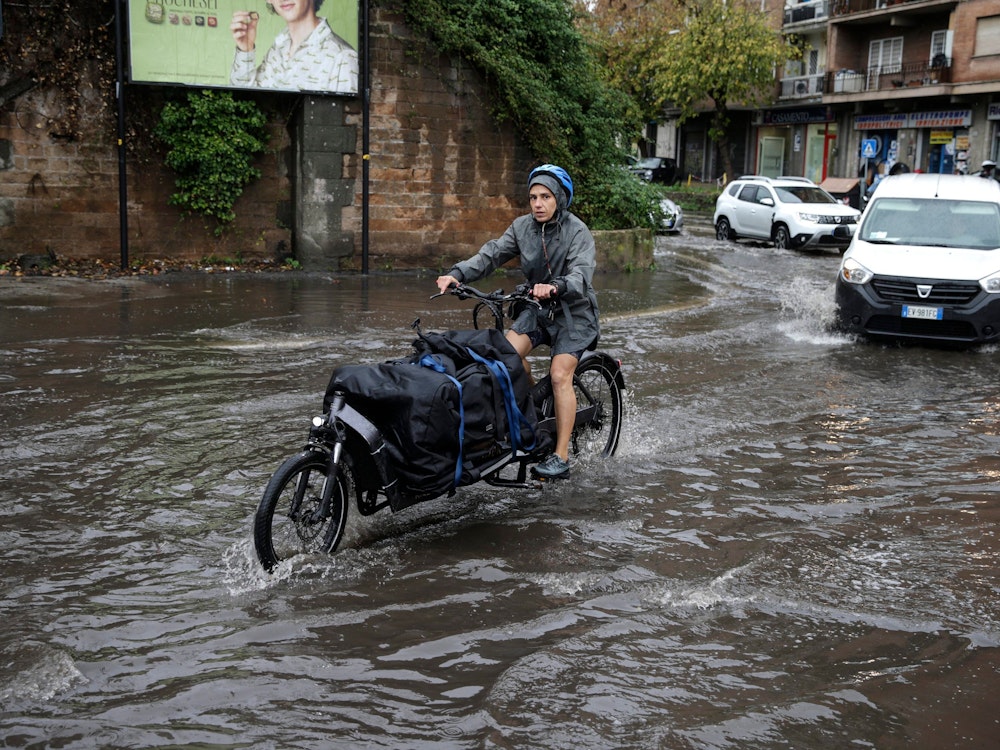 22.11.2022, Italien, Rom: Radfahrer und Autos fahren bei schlechtem Wetter und Überschwemmungen aufgrund von starkem Regen auf einer Straße in der Hauptstadt . Foto: Cecilia Fabiano/LaPresse via ZUMA Press/dpa +++ dpa-Bildfunk +++