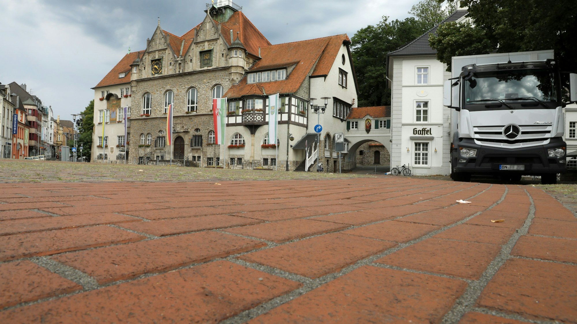 Im Vordergrund ist das rote Pflaster des Konrad-Adenauer-Platzes zu sehen, im Hintergrund das Rathaus Bergisch Gladbach.