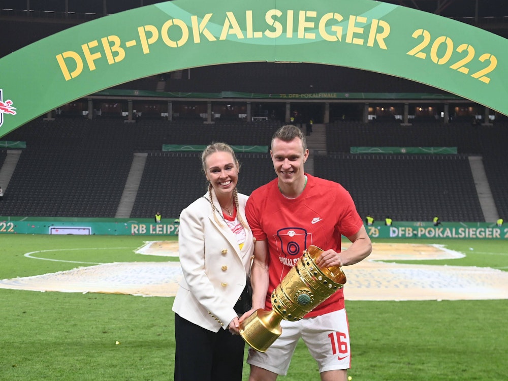 Lukas Klostermann und seine Freundin Laura alten den DFB-Pokal fest.