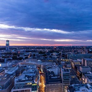 Ein Panoramabild der Stadt Köln bei dämmerndem Abendlicht.