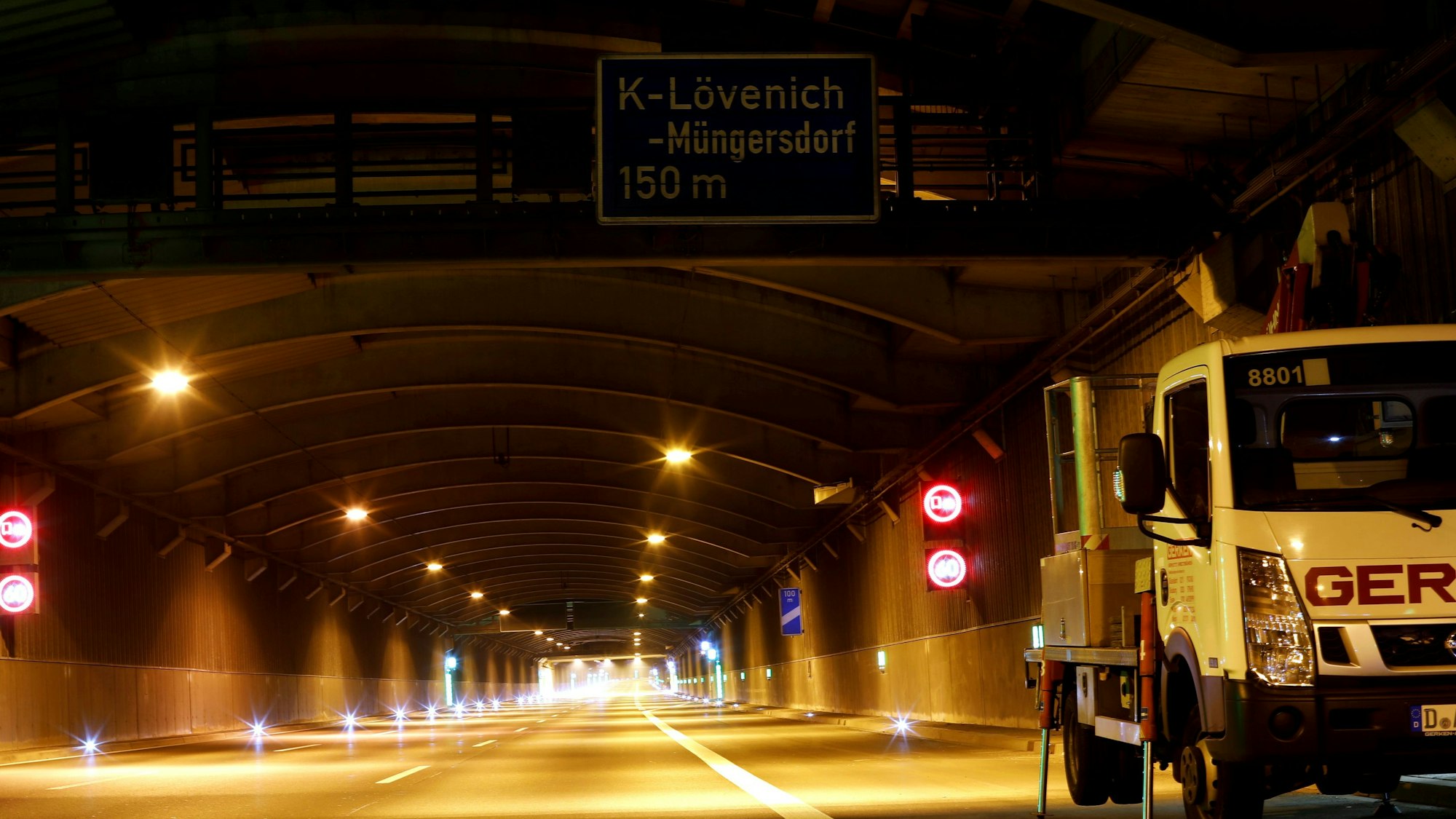 Der Autobahntunnel in Köln-Lövenich. Vorne rechts steht ein Wartungsfahrzeug. Ansonsten ist der nächtliche Tunnel aufgrund der Sperrung leer.