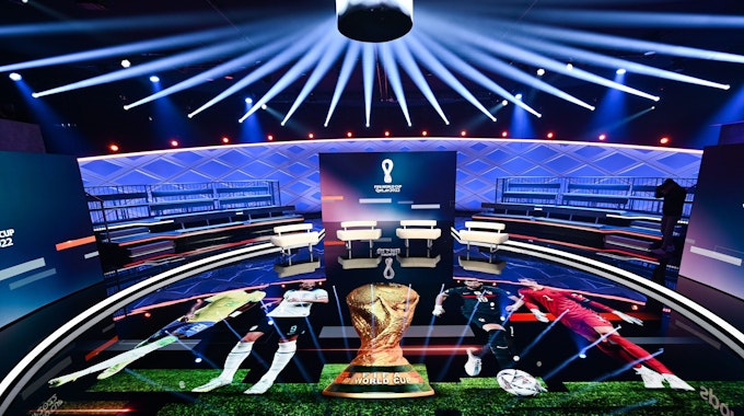 Das WM-Studio von Ard und ZDF ist in einem Halbkreis aufgebaut. Auf dem Boden werden verschiedene WM-Stars um den WM-Pokal her projiziert. Das Studio ist durch die Beleuchtung in ein dunkles Blau getönt.