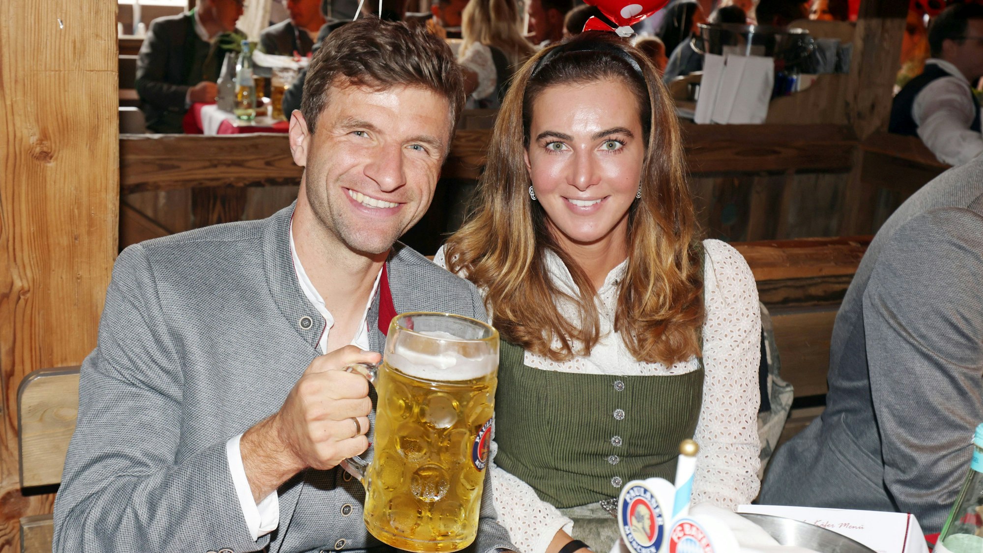 Thomas Müller mit einem Bier in der Hand und Ehefrau Lisa im Arm beim Oktoberfest.