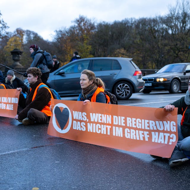 Klimaaktivisten der Umweltschutzbewegung Letzte Generation sitzen auf der Prinzregentenstraße in München und blockieren den Verkehr.