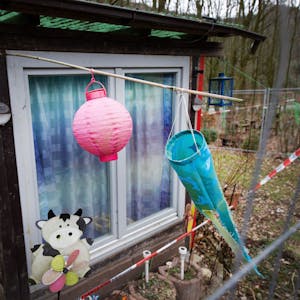 Hinter einem Zaun und Polizeiabsperrband ist ein Lampion und ein Windspiel auf dem Campingplatz Eichwald zu sehen. (Archivbild)