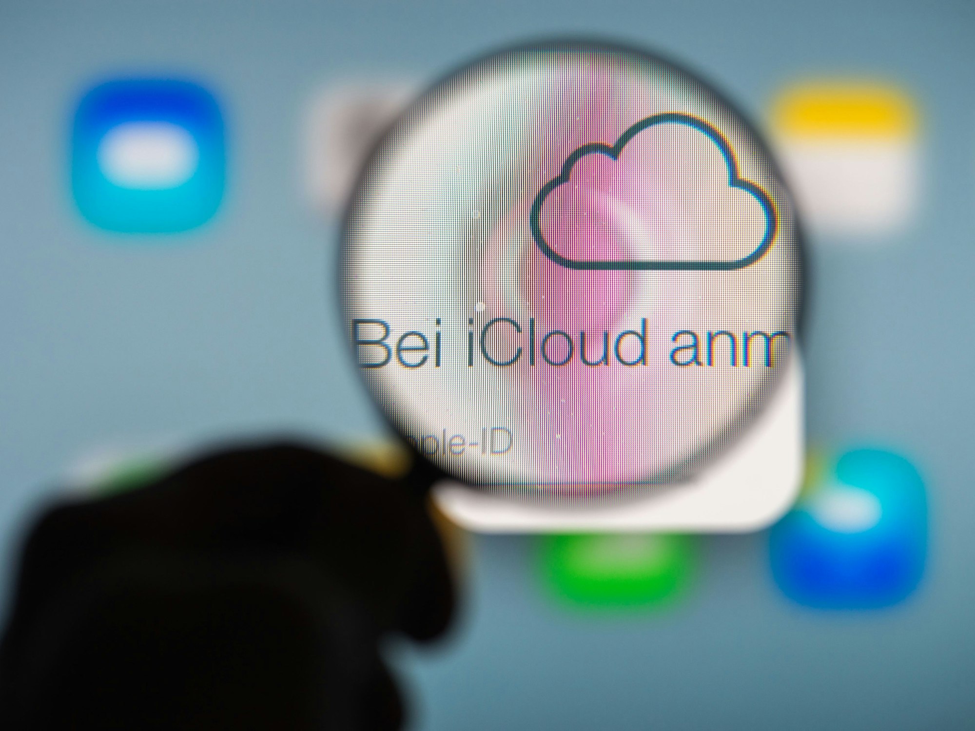 Eine Hand hält am 13.01.2014 in Straubing (Bayern) ein Vergrößerungsglas vor die Internetseite des Online-Speicherdienstes iCloud von Apple.