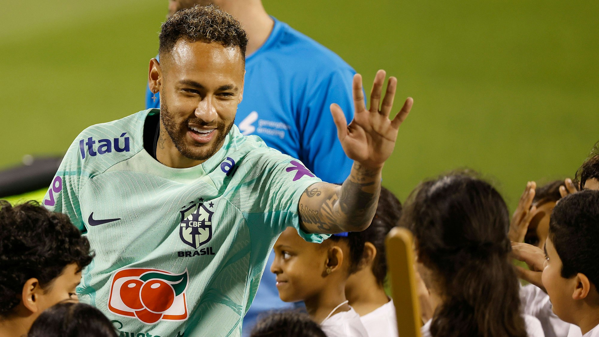Neymar klatscht beim Training der Nationalmannschaft Brasiliens mit Kindern ab.
