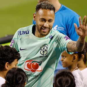 Neymar klatscht beim Training der Nationalmannschaft Brasiliens mit Kindern ab.