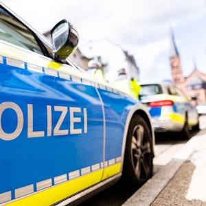 Zwei Einsatzfahrzeuge der Polizei stehen in Freiburg am Straßenrand.
