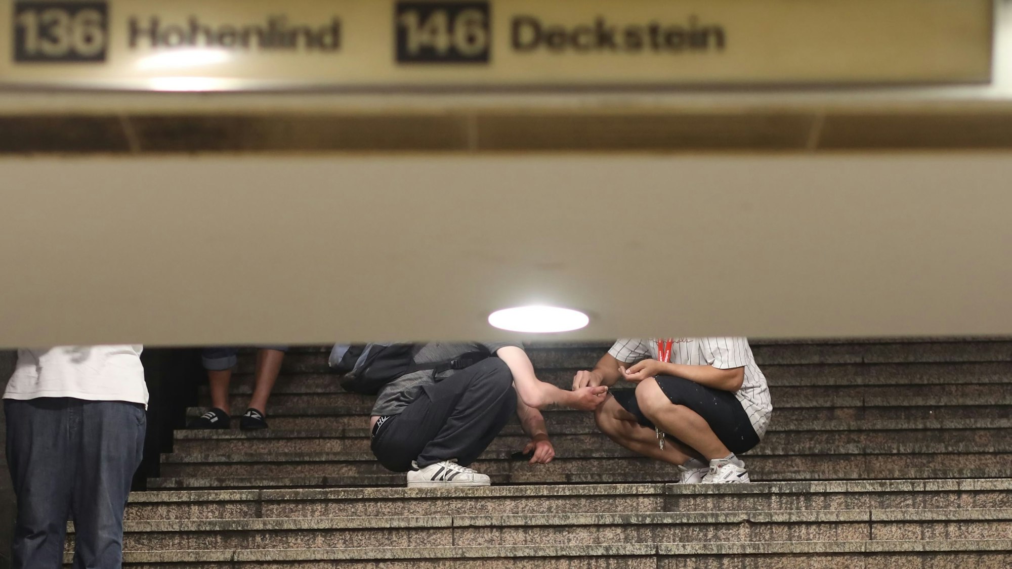 Zwei Passanten auf der Treppe zur U-Bahn: Hier findet scheinbar gerade ein Drogengeschäft statt.