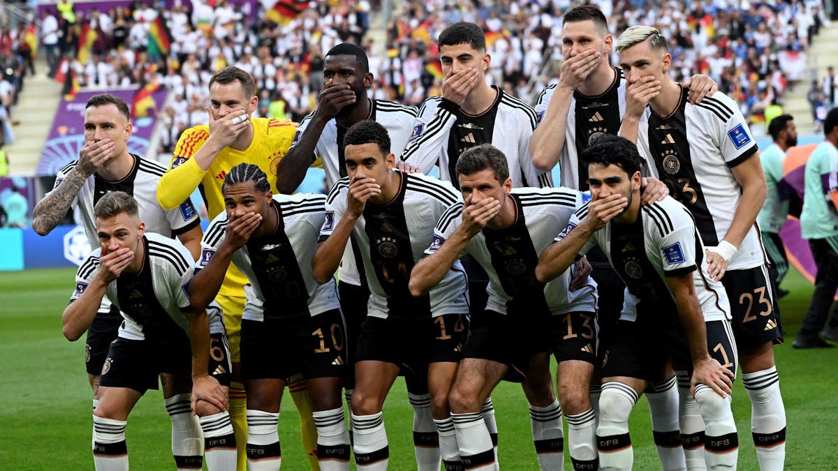 Die deutschen Nationalspieler halten sich beim Mannschaftsfoto den Mund zu.