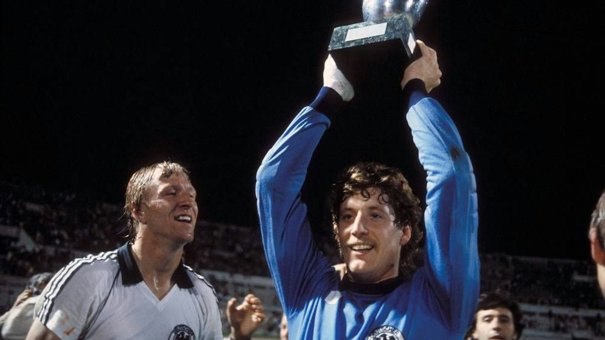 Toni Schumacher hält 1980 den Europameister-Pokal hoch (links Horst Hrubesch). Das Spiel absolvierte er mit einer gebrochenen Mittelhand.