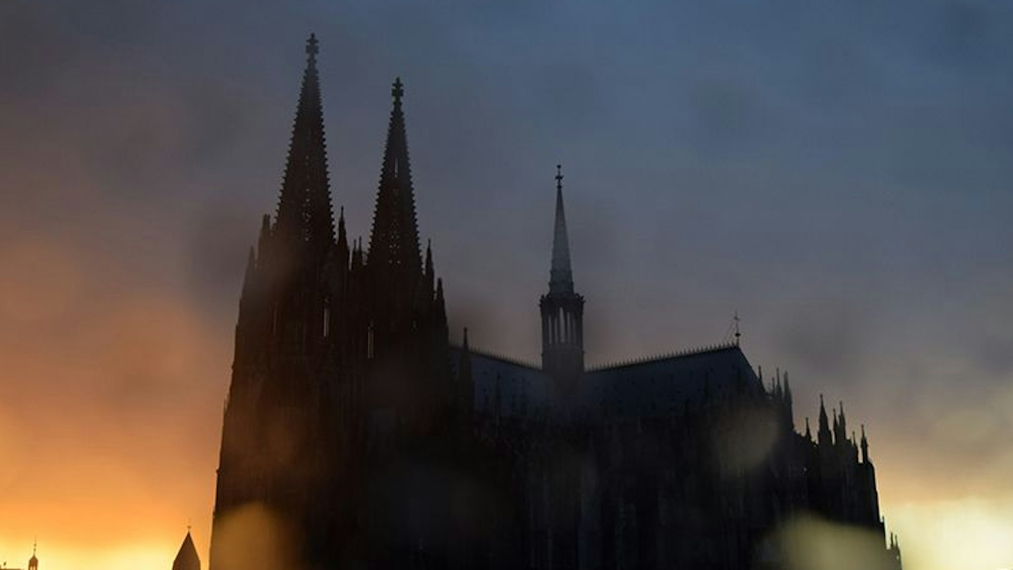 Bild aus dem Kölner Band „Dom“. Der Dom bei Sonnenuntergang. Auf der Linse sind Wassertropfen.