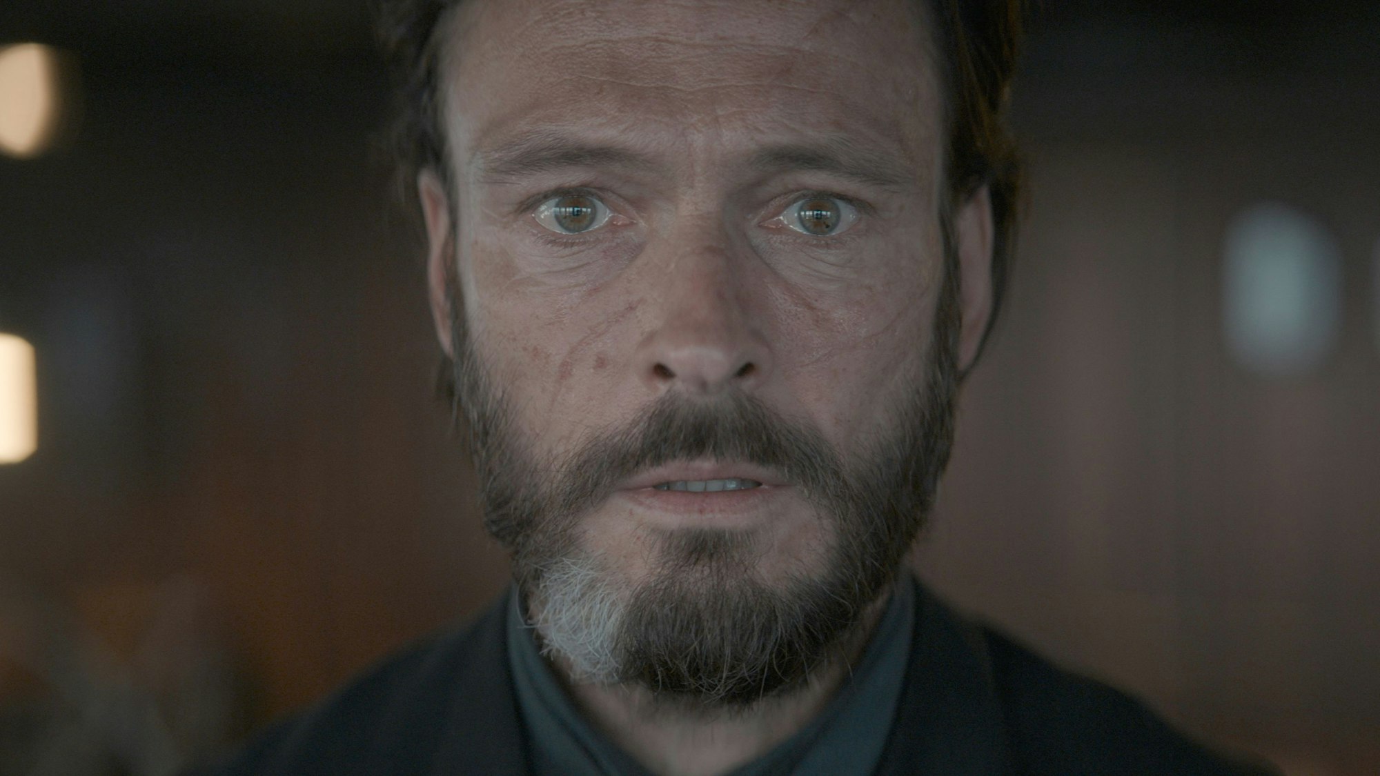 Andreas Pietschmann als Eryk Larsen blickt direkt in die Kameralinse.