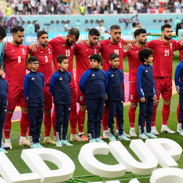 Die iranische Nationalmannschaft steht vor dem Anpfiff auf dem Rasen und schweigt bei der Nationalhymne ihres Landes.