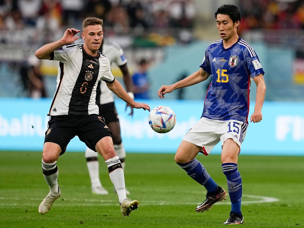 Germany's Joshua Kimmich, left, and Japan's Daichi Kamada battle for the ball during the World Cup group E soccer match between Germany and Japan, at the Khalifa International Stadium in Doha, Qatar, Wednesday, Nov. 23, 2022. (AP Photo/Ebrahim Noroozi)