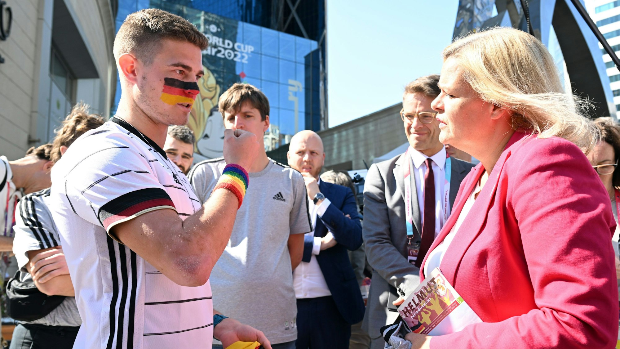 Nancy Faeser (SPD), Bundesministerin des Innern, und Deutschland-Fan Bengt Kunkel unterhalten sich bei einem Pressetermin vor der Mobilen Fan-Botschaft des DFB in Doha.