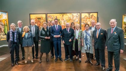 Ministerpräsident Hendrik Wüst und Mitglieder des Stifterrats stehen im Wallraf-Richartz-Museum vor einem mittelalterlichen Gemälde.&nbsp;
