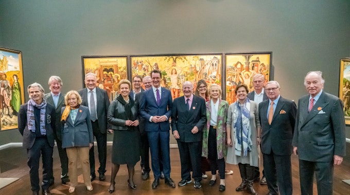 Ministerpräsident Hendrik Wüst und Mitglieder des Stifterrats stehen im Wallraf-Richartz-Museum vor einem mittelalterlichen Gemälde.&nbsp;