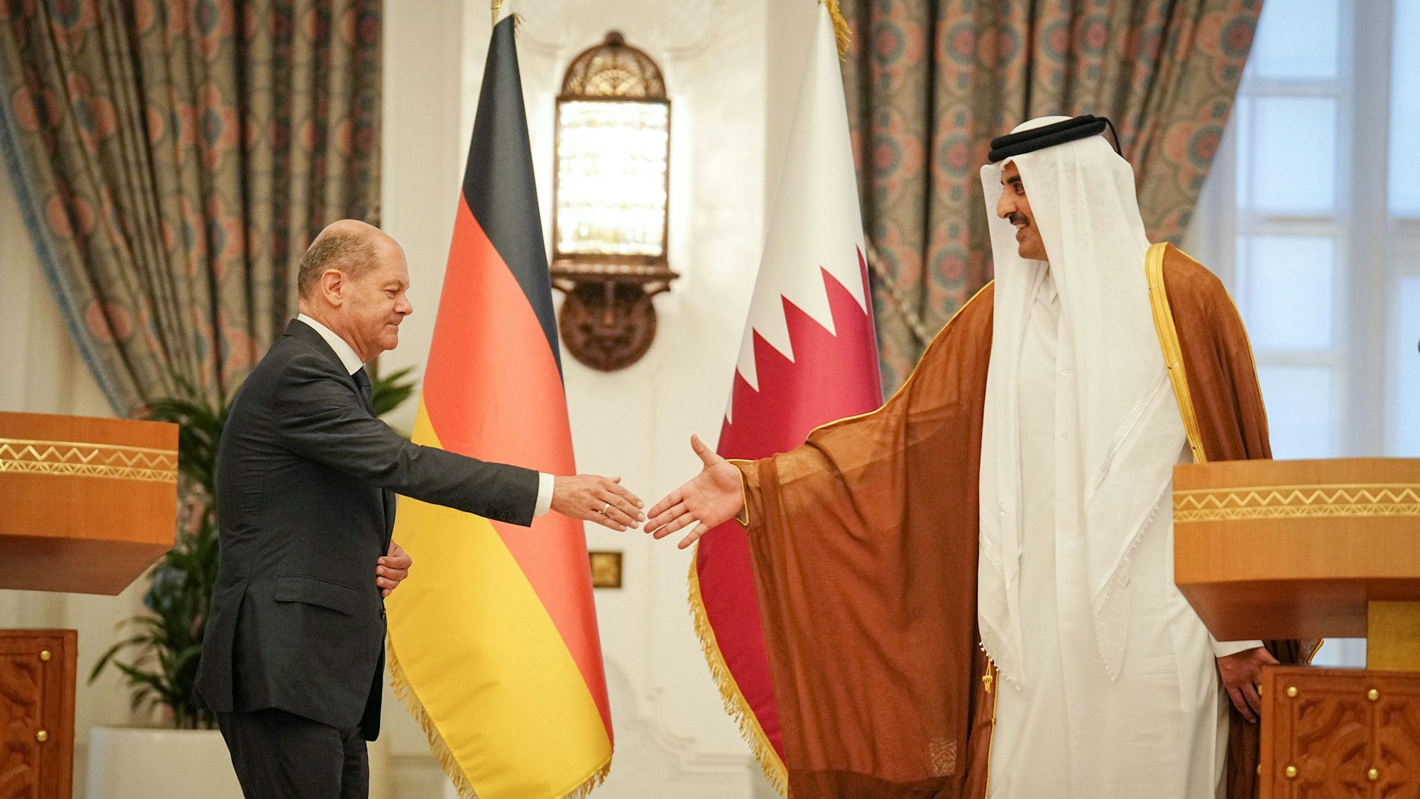 Bundeskanzler Olaf Scholz (l, SPD) und der Emir von Katar, Tamim bin Hamad Al Thani, reichen sich nach ihrem Gespräch und dem Pressestatement die Hände