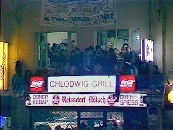 Das Bild zeigt den Chlodwig Grill mit demonstrierenden Menschen.