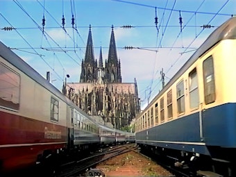 Das Bild zeig im Vordergrund zwei Bahnen und im Hintergrund den Kölner Dom.