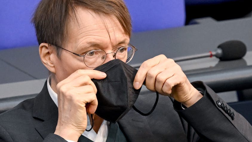 Karl Lauterbach (SPD), Bundesminister für Gesundheit, setzt seine Maske nach seiner Rede bei der Sitzung im Bundestag wieder auf.