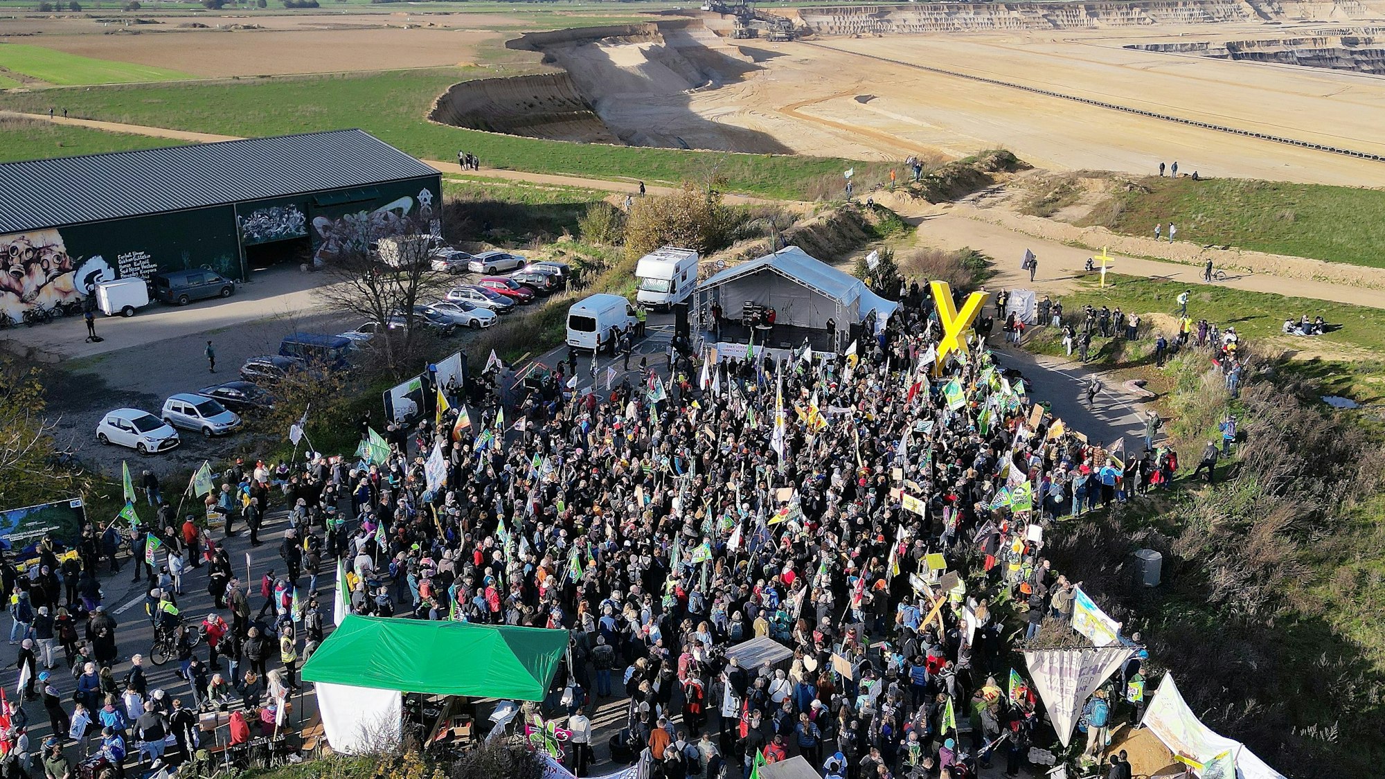 Die Drohnenaufnahme zeigt Demonstrationsteilnehmer dicht an der Kante des Tagebaues bei Erkelenz.