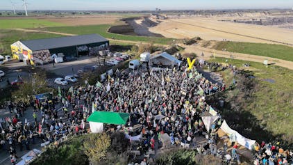 06.11.2022, Nordrhein-Westfalen, Erkelenz: Demonstrationsteilnehmer dicht an der Kante des Tagebaues. (Aufnahme mit einer Drohne) Foto: David Young/dpa +++ dpa-Bildfunk +++