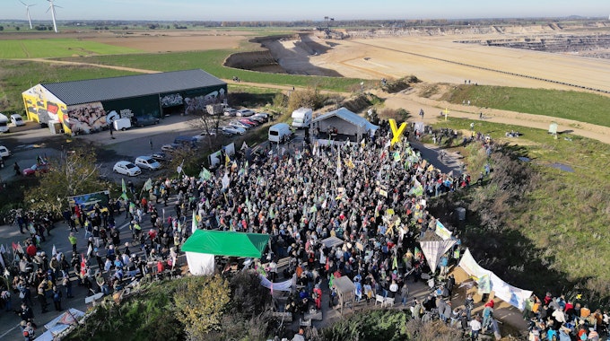06.11.2022, Nordrhein-Westfalen, Erkelenz: Demonstrationsteilnehmer dicht an der Kante des Tagebaues. (Aufnahme mit einer Drohne) Foto: David Young/dpa +++ dpa-Bildfunk +++