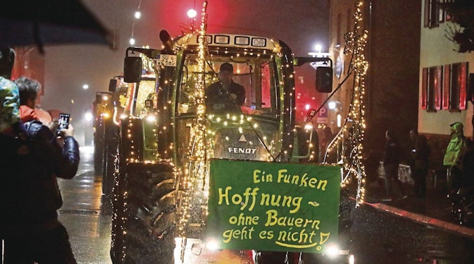 Ein leuchtender Traktor rollt mit der Aufschrift „Ein Funken Hoffnung – Ohne Bauern geht es nicht“ durch Overath-Heiligenhaus.