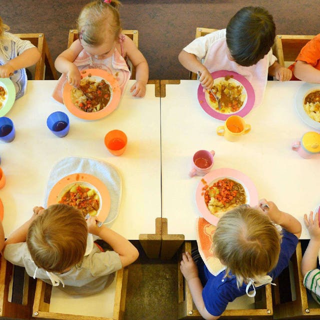 Kinder sitzen in einer Kindertageseinrichtung beim Mittagessen.&nbsp;