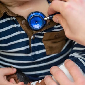 Ein Arzt untersucht ein Kind mit einem&nbsp;Stethoskop.