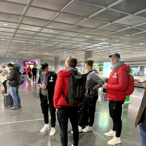 Profis und Betreuer des 1. FC Köln stehen am Donnerstag am Frankfurter Flughafen.