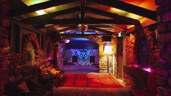 Der abedunkelte Innenraum des Lemuria mit ausgelegten Teppichen und Backsteinwänden.