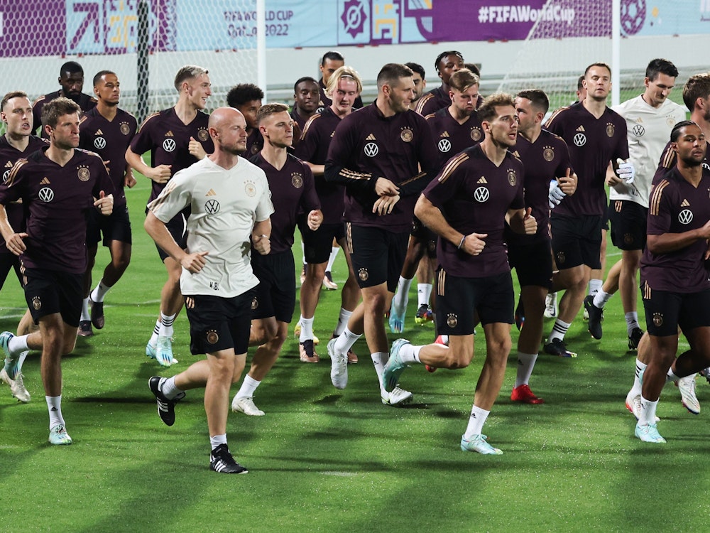 Die deutsche Mannschaft läuft in einem Stadion in Katar über den Rasen.