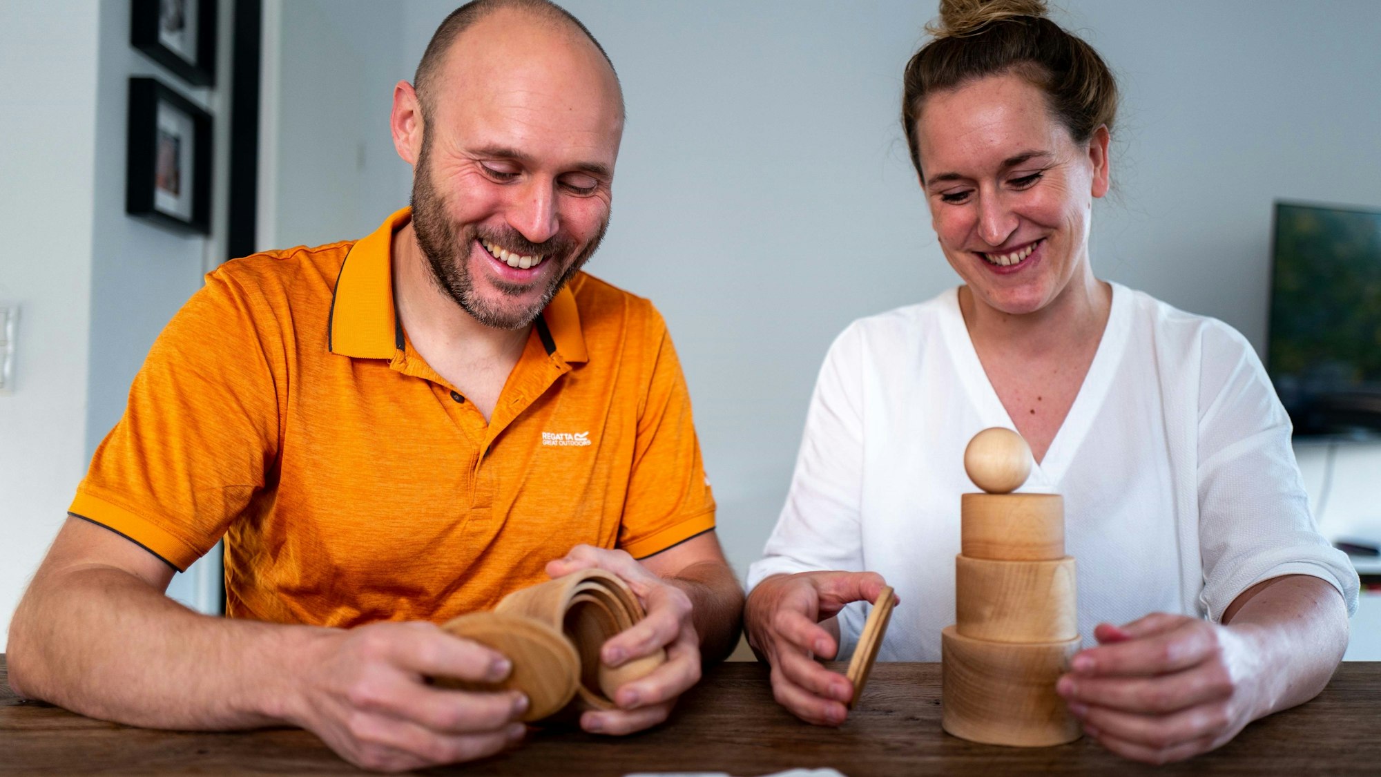 Karin Schimkus und Rene Kurzok mit Holzspielzeug, das sie für ihre Methode zur Sprachentwicklung für Kinder einsetzen.