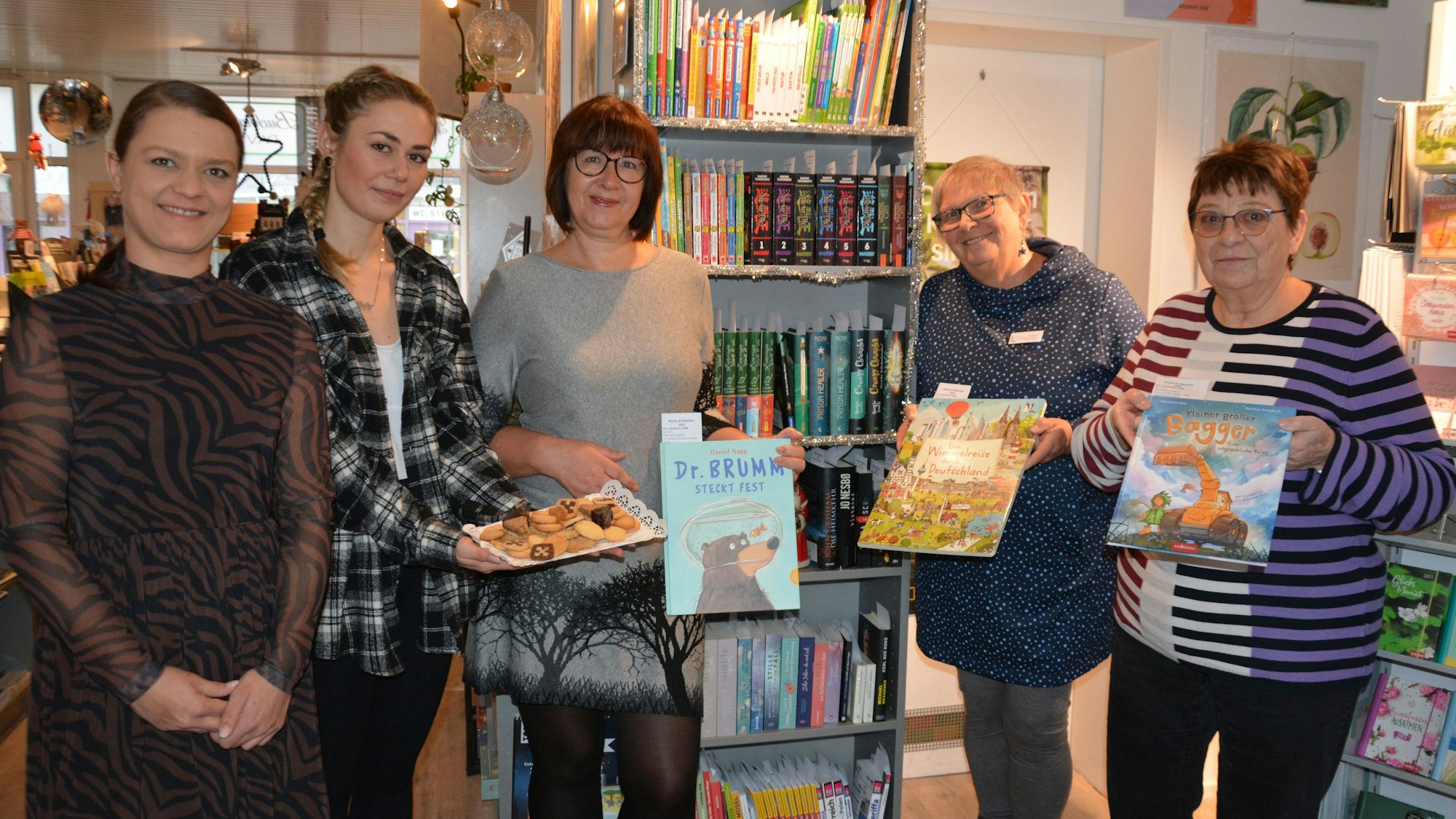 Buchhändlerin Julia Pavlik, Linda Mae Schneppenheim (Café Büchel), Ingrid Pohl (Leiterin Stadtbücherei) und Dagmar Pärsch-Roos und Angelika Legrand vom Förderverein der Bücherei stehen vor dem Aktionsregal mit Büchern.